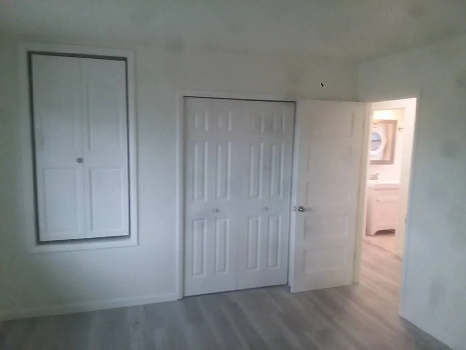 Interior room with white drywall, six-panel doors, and laminate flooring installation