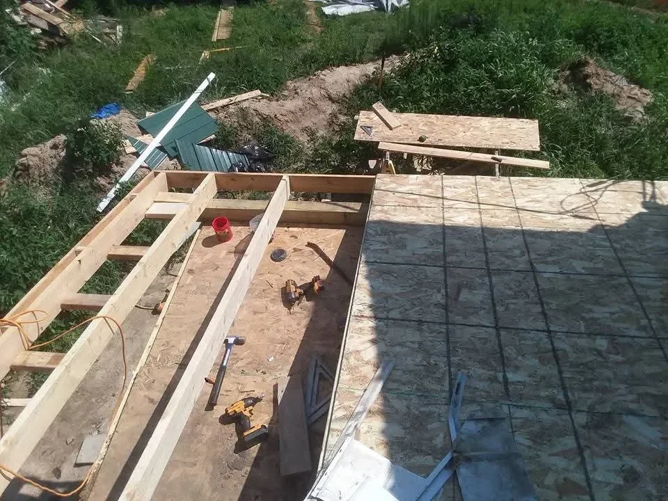 Roof framing with plywood sheathing, dimensional lumber trusses, and metal flashing installation