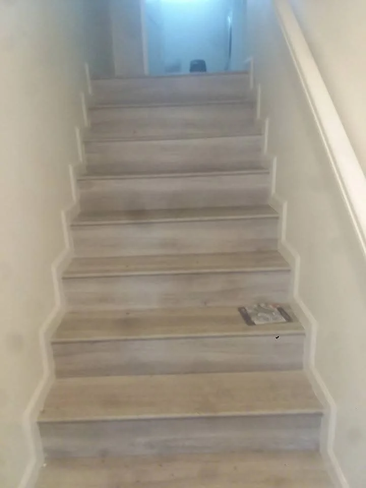 Light oak wooden staircase with white stringers in residential interior