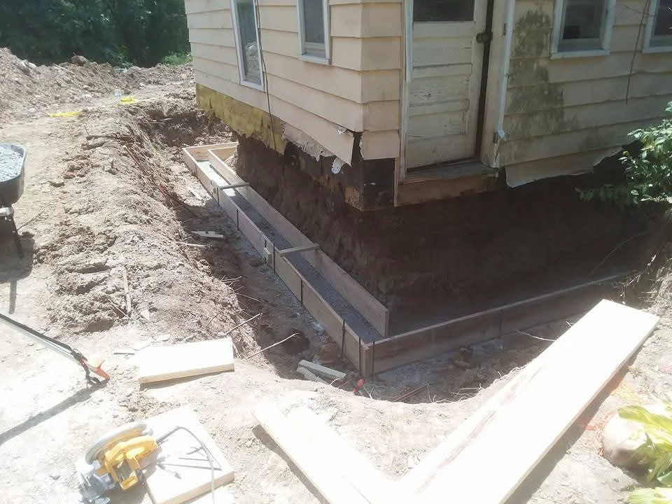 Foundation excavation with concrete forms and footings installed around house base