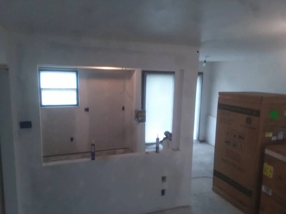 Frameless glass shower enclosure with chrome hardware and finished drywall surround