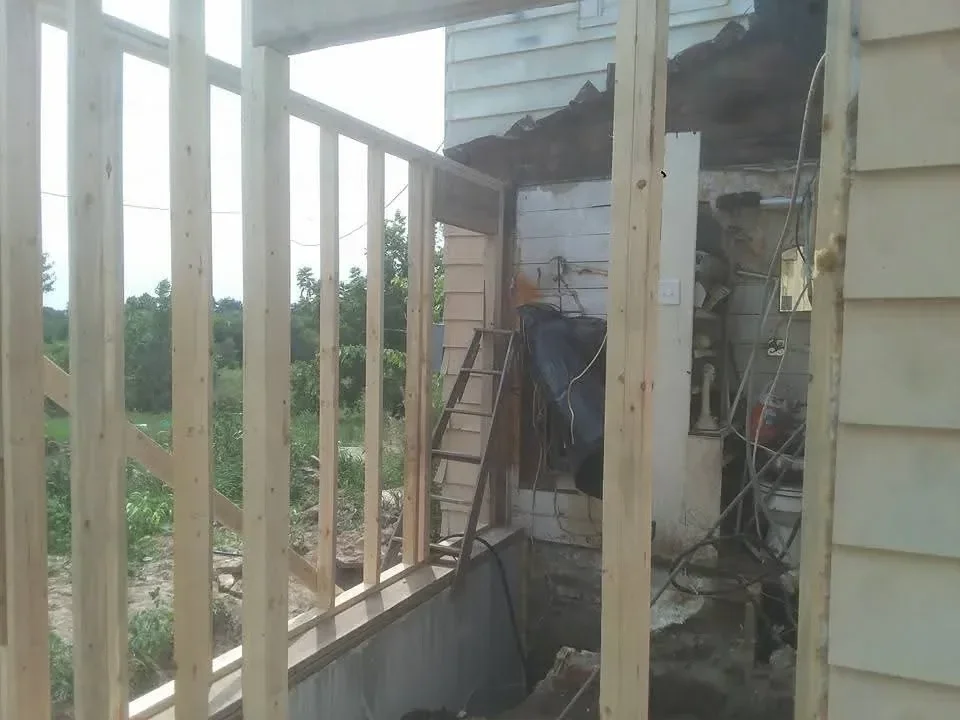 Wooden roof framing with beams, rafters, and skylight openings under construction