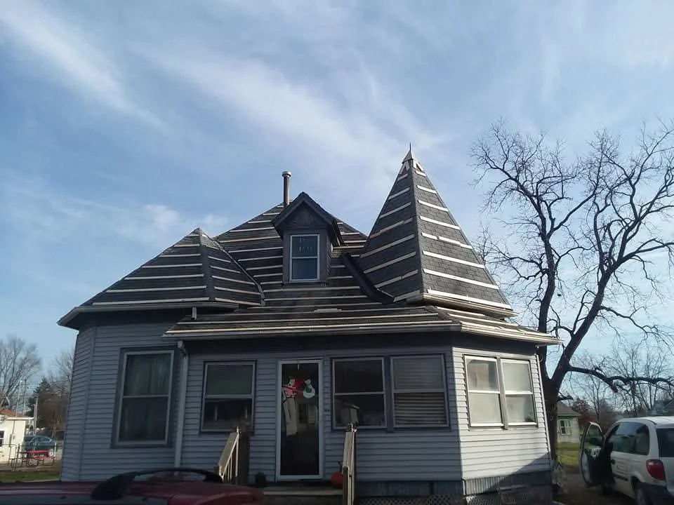 Dark gray architectural shingles on Victorian home with two peaked gables and dormer window