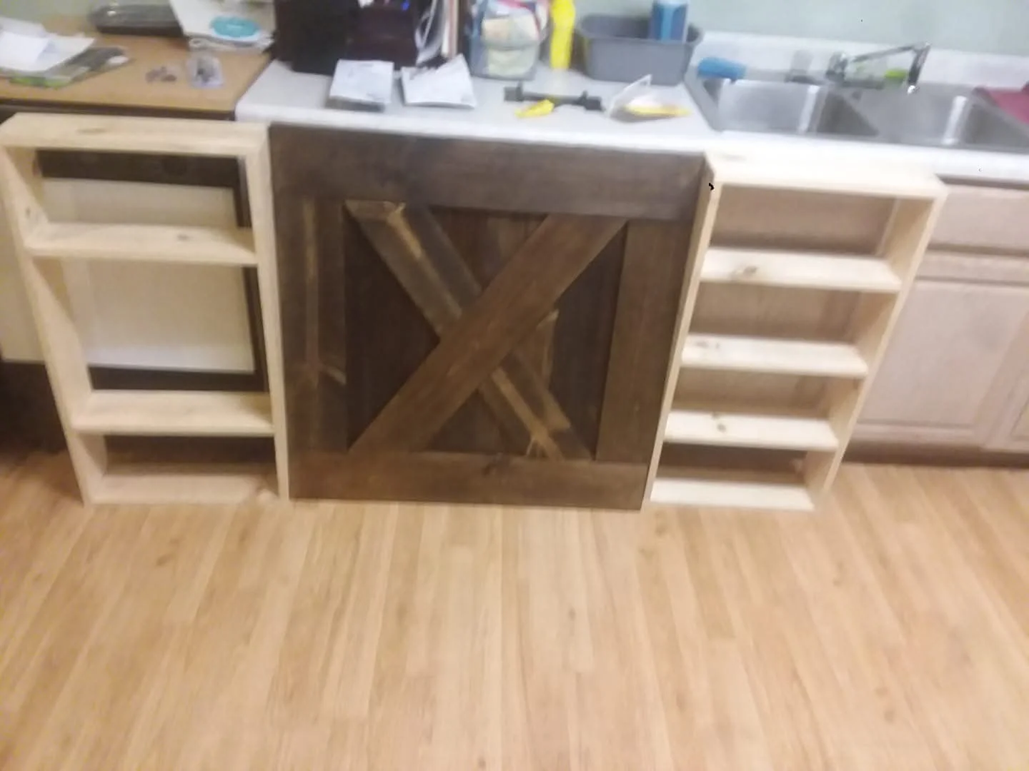 Custom wood cabinetry with X-pattern door and open shelving units installed in kitchen