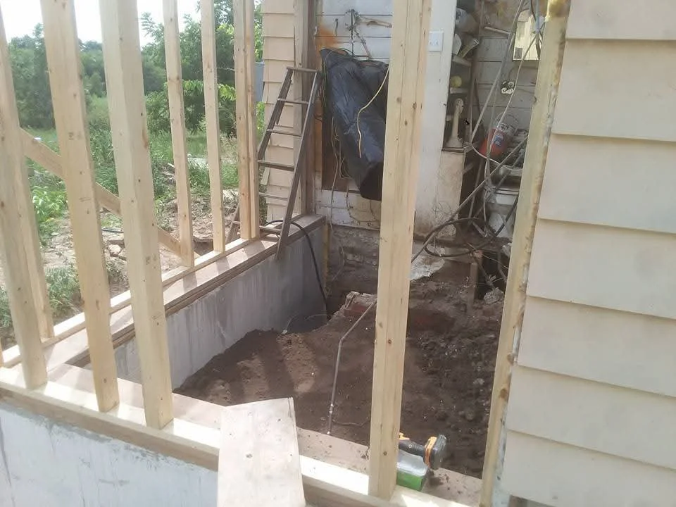 Concrete foundation with pressure-treated wood framing and excavated soil base for residential addition