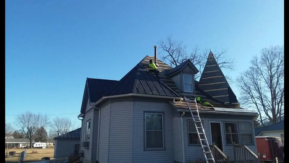 Standing-seam metal roof installation on Victorian home with multiple peaks and dormers
