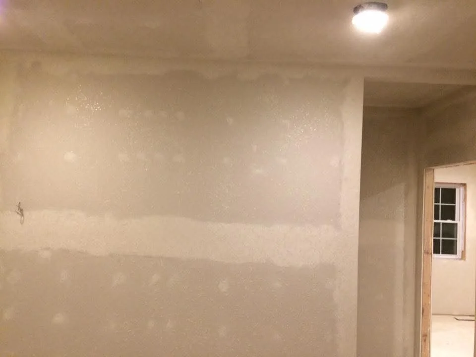 Finished drywall walls with taped joints and smooth compound finish in residential interior