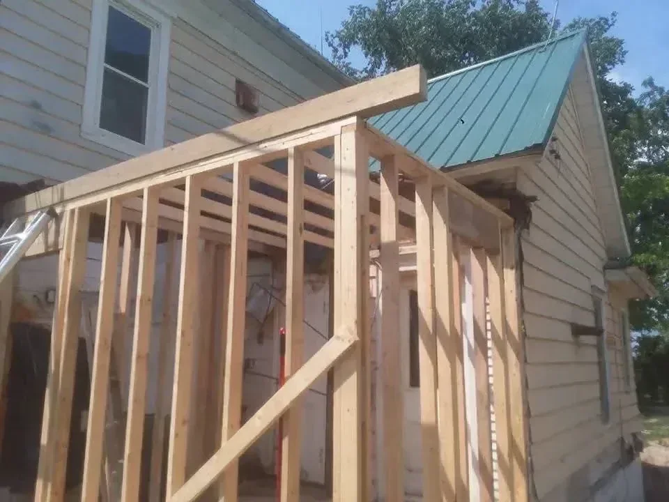 Pressure-treated lumber deck framing with joists, beams, and curved rim joist detail