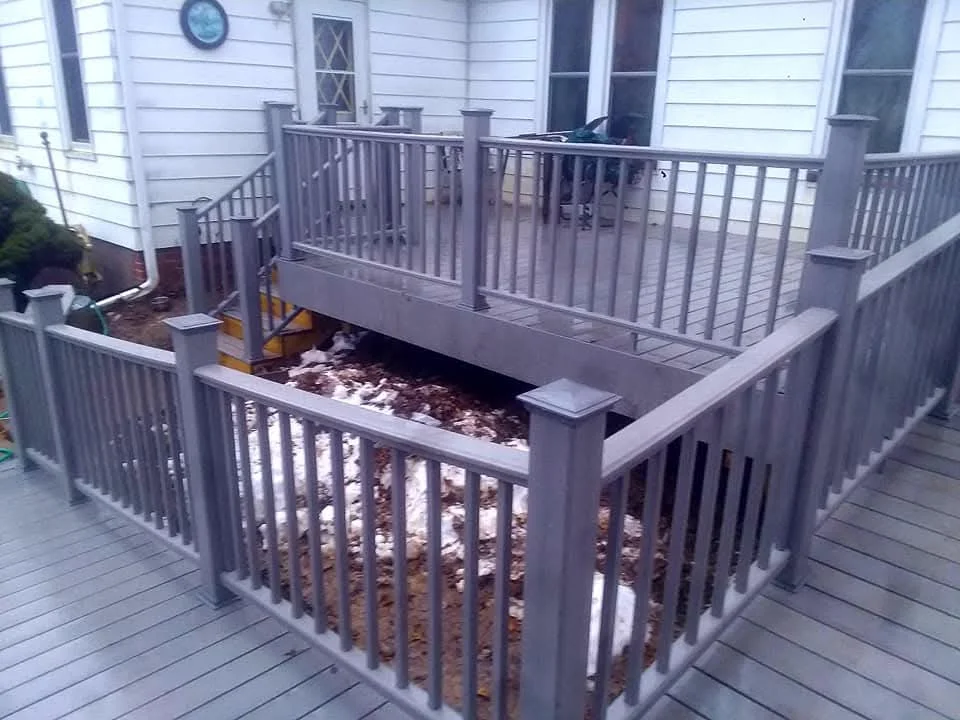 Two-level composite deck with gray aluminum railings, planter boxes, and mulch landscaping