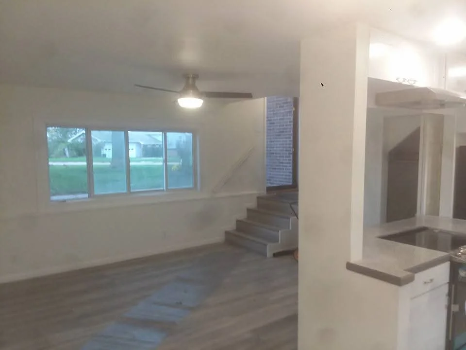 Interior renovation with drywall, painted walls, new stairs, and large windows