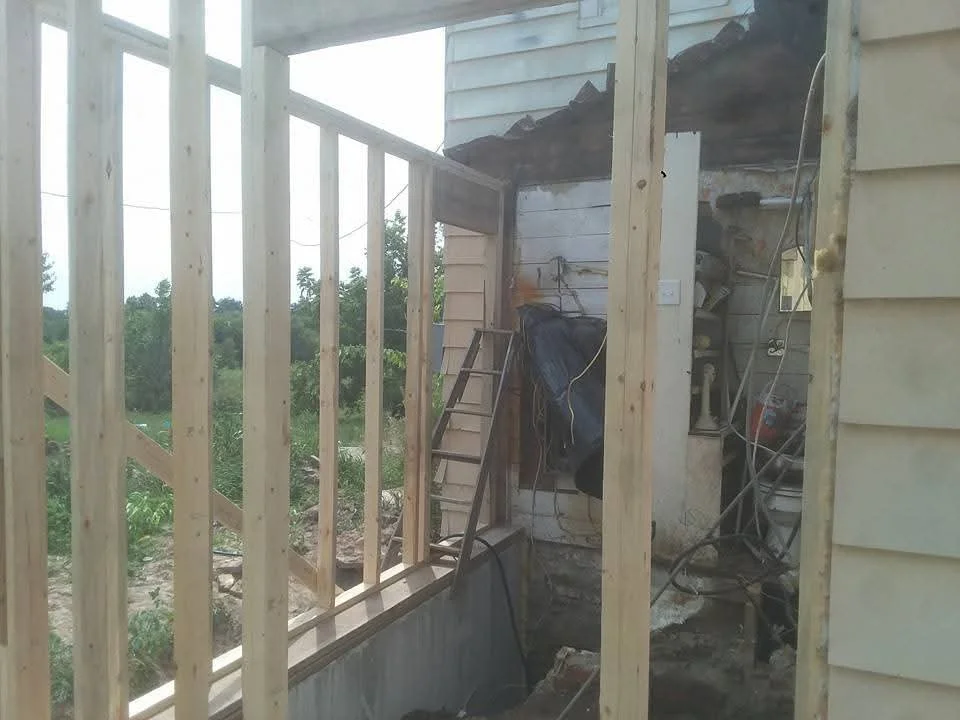 Wooden roof framing with vertical posts and corrugated metal roofing panels under construction
