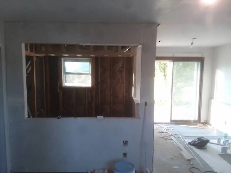 Interior framing with wood studs, drywall, and window openings in renovation project
